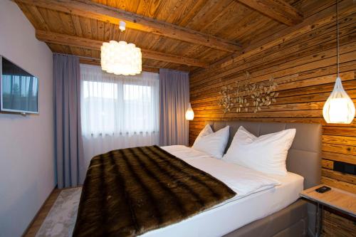埃尔毛Appartement Enzian & Mark的一间卧室设有一张带木制天花板的大床