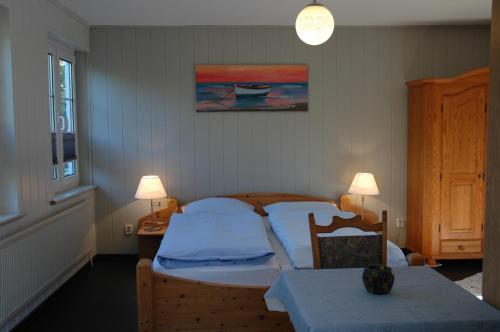 卡珀尔恩卡培尔纳霍夫酒店的一间卧室配有一张床、一张桌子和两盏灯。