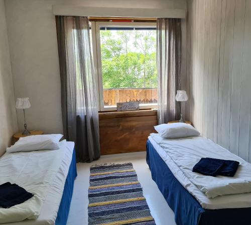 Saltvik萨尔特维克住宿加早餐旅馆的带窗户的客房内的两张床