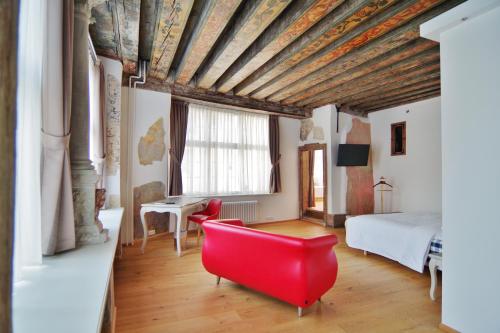 塔林Hotel Regent Tallinn的一间设有红色椅子和一张床的房间