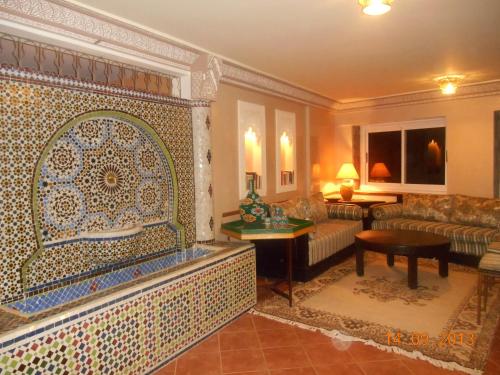 奥比丹Tigmi Dar Samy的带沙发和瓷砖墙的客厅