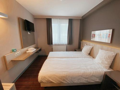圣胡伯特Hotel les100ciels的酒店客房,配有床和电视