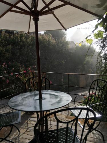 圣锡尔克－拉波皮L’Auberge du Sombral的露台的遮阳伞下的桌椅