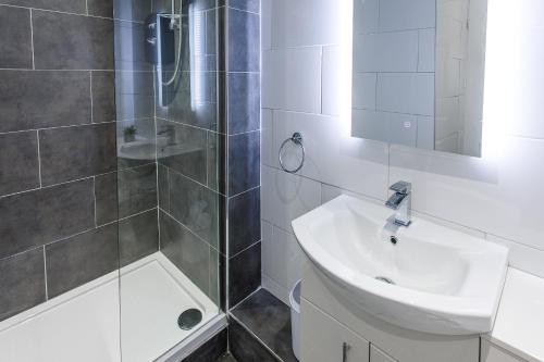 泰恩河畔纽卡斯尔Stylish Apartment in the heart of Newcastle centre的一间带水槽和淋浴的浴室