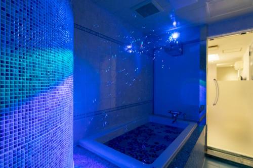 茨城Hotel Luna Ibaraki(Adult Only)的蓝色的浴室设有蓝色灯光浴缸