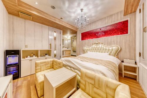 茨城Hotel Luna Ibaraki(Adult Only)的一间卧室配有一张大床和一张沙发