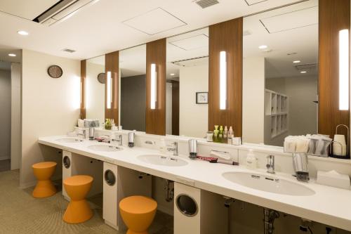 东京赤坂弗斯特胶囊公寓的一间带三个水槽和大镜子的浴室