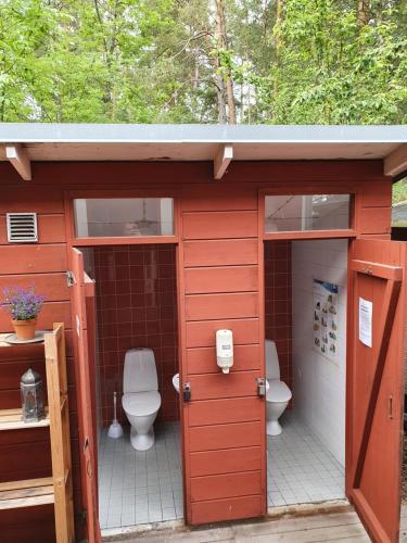 Norra LjusteroSiaröfortet Skärgårdskrog och Pensionat的浴室设有两个卫生间,位于红色的棚子里