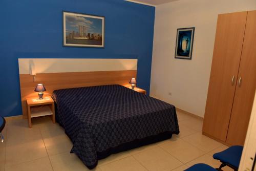切萨雷奥港Bilocali Civico16的一间卧室设有一张床和蓝色的墙壁