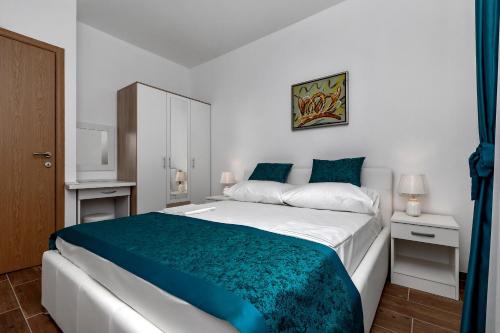 马卡尔斯卡Apartments Villa Medo的一间卧室配有一张带蓝色毯子的大床