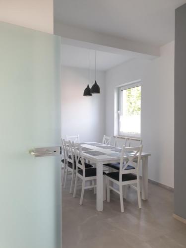 SkawaPokoje u Jasia i Małgosi的白色的用餐室配有白色的桌椅