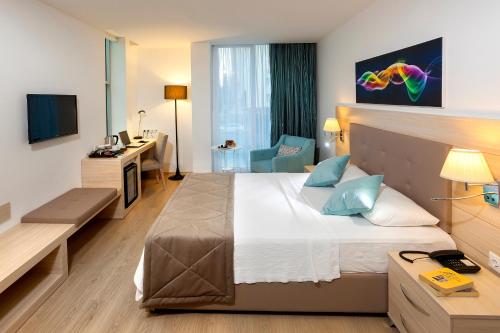 安塔利亚客房公寓式酒店的酒店客房设有一张大床和一张书桌。