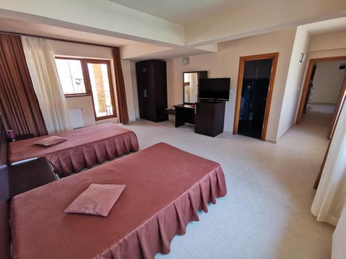 北马马亚-讷沃达里Vila Gente的酒店客房设有两张床和电视。