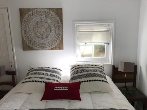 阿尔宗La petite Escarpolette的一间卧室配有一张红色枕头的床