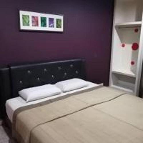 伯恩仓Emerald Inn的卧室内的一张床位,带紫色墙壁