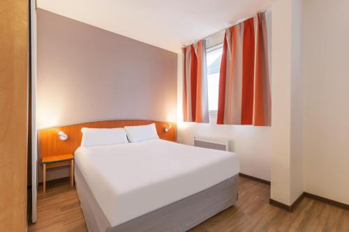 斯特拉斯堡斯特拉斯堡城市公寓的卧室配有白色的床和窗户。
