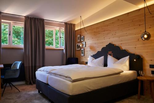 费尔德基尔兴-韦斯特拉姆阿斯克巴切尔霍夫酒店的一间卧室设有一张带木墙的大床