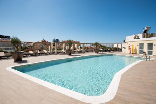 埃斯托利尔Vila Gale Estoril - Adults Friendly的一座配有桌椅的酒店游泳池