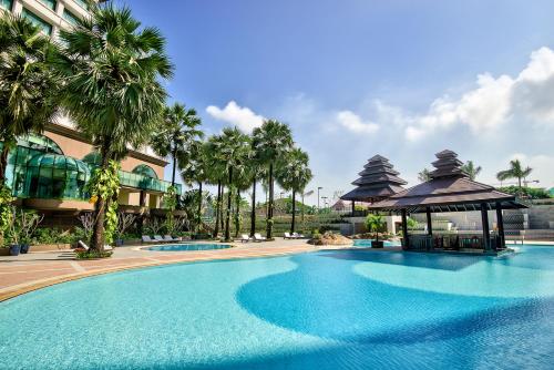 仰光仰光塞多纳酒店的一座棕榈树建筑旁边的大型游泳池