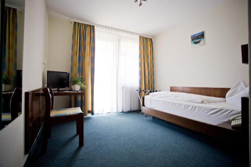 莫斯巴赫Hotel Lindenhof的卧室配有床、椅子和窗户。