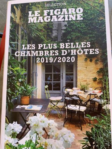 CleppéORANGERIE de CHATEL-Selection FIGARO & ELLE Magazine的一个带桌椅的庭院的杂志封面