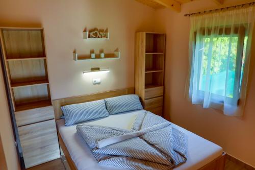 巴拉通马里亚弗都Hullám Nyaraló的一间卧室配有一张带窗户和书架的床