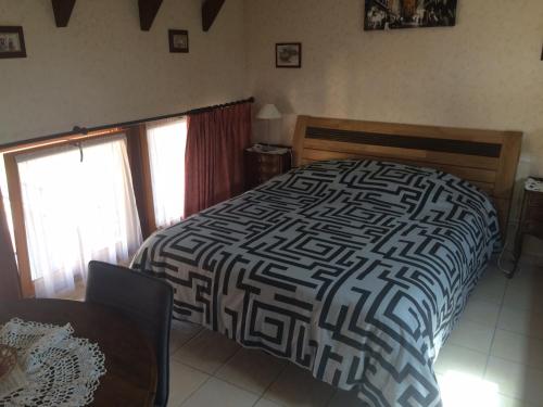 里珀舍姆Mélodies d'Alsace的一间卧室配有一张带黑白色棉被的床