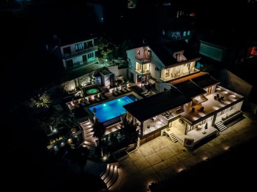 乌尔齐尼Apartments Secret Garden的享有房子空中景色,晚上有游泳池