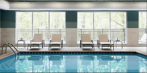 GoodlandHoliday Inn Express & Suites - Goodland I-70, an IHG Hotel的酒店游泳池设有椅子和桌子