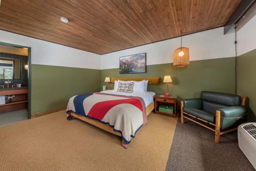 南太浩湖Station House Inn South Lake Tahoe, by Oliver的一间卧室配有一张床和一把椅子