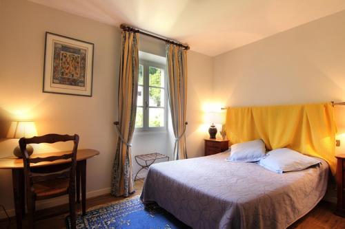 圣锡尔克－拉波皮L’Auberge du Sombral的一间卧室配有一张床、一张书桌和一个窗户。
