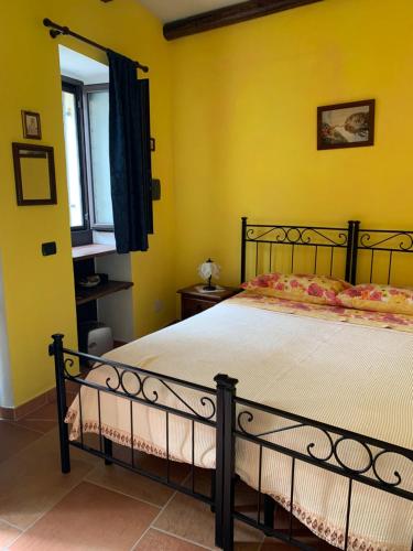 ScapoliIL Borgo 31的一间卧室设有一张黄色墙壁和窗户的床