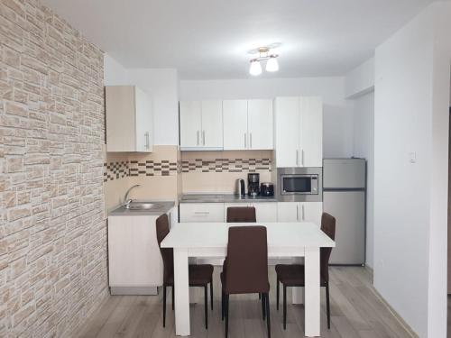 阿尔杰什河畔库尔泰亚Apartament Posada的厨房配有白色的桌椅