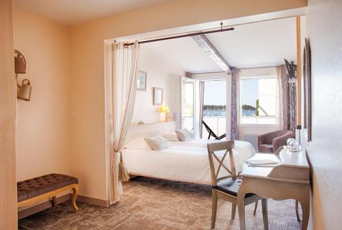 拉尔莫巴当Hotêl & Spa Du Parc Fétan的一间卧室配有一张床、一张书桌和一个窗户。