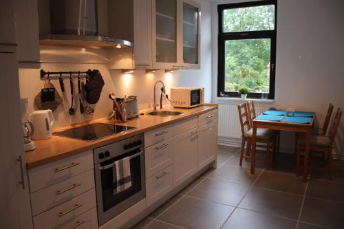 瓦尔斯罗德Ferienwohnung Eddelhoff的厨房配有白色橱柜、桌子和窗户。