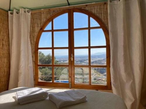 阿尔加罗沃Treehouse ,Casa Arbol, with Spa的一间卧室设有大窗户,床上配有两个枕头