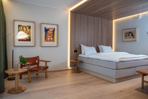 克里斯蒂安桑Thon Partner Hotel Norge的卧室配有1张床、1张桌子和1把椅子