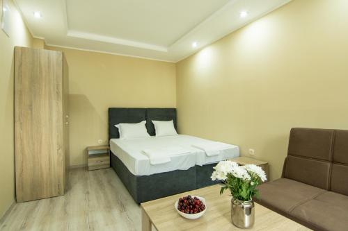 桑丹斯基Бунгала Сън Сити的一间卧室配有一张床、一张沙发和一张桌子