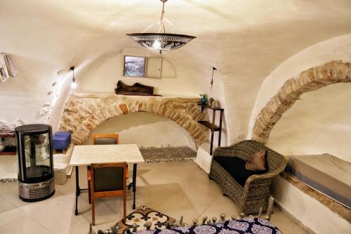 耶路撒冷Sweet ‘En Kerem View的客厅设有壁炉、桌子和椅子