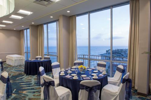 文图拉文图拉海滩皇冠假日酒店的一间会议室,配有桌椅和大窗户