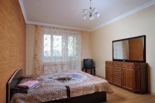 鄂木斯克Omsk Sutki Apartment on 70 let octyabrya 10/3的一间卧室配有一张床、梳妆台和电视。