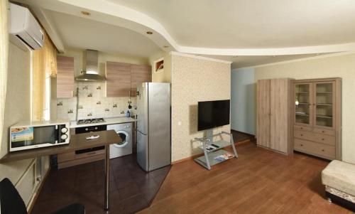 鄂木斯克Omsk Sutki Apartments Krasny Put 67的一间带冰箱和桌子的厨房