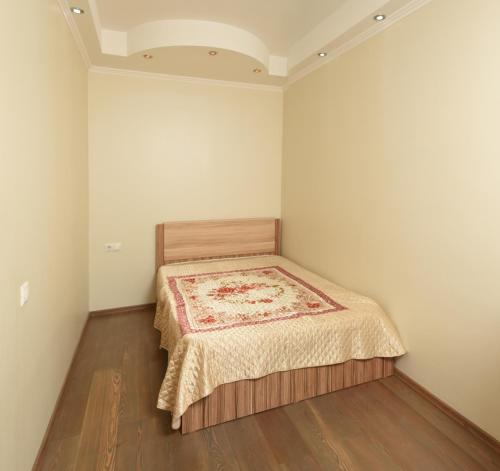鄂木斯克Omsk Sutki Apartments Krasny Put 67的小卧室配有一张铺着地毯的床