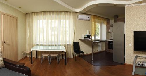 鄂木斯克Omsk Sutki Apartments Krasny Put 67的一间带桌子的客厅和一间厨房
