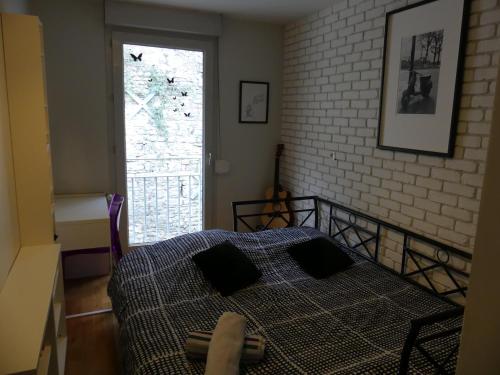 卡威尔奎Appt T3, 55m2 proche Parc Tête D'or et quais du Rhône的一间卧室设有一张床和砖墙