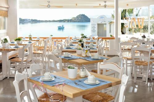 普拉迪斯亚罗斯贝斯特韦斯特佩尼诺斯酒店的一间设有桌椅并享有水景的餐厅