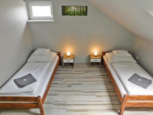 LevélKorona Panzió的两张床位于带两盏灯的墙上。