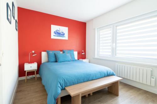 滨海布洛涅"Les Mouettes"的一间卧室设有蓝色的床和红色的墙壁