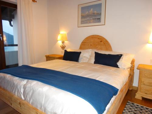 布里萨戈Brilago 6的一间卧室配有一张带蓝白色床单的大床