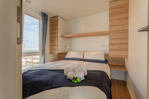 朱利亚诺瓦AQUA RESORT GIULIANOVA - Houseboat Experience的卧室里设有一张床,上面有一只动物